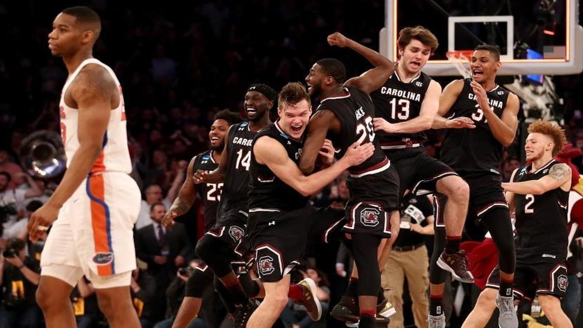 Maik Kotsar (21) and Justin McKie (20) of the South Carolina Gamecocks celebrate with their teammates after defeating the Florida Gators with a score of 77 to 70 to win the 2017 NCAA Men's Basketball Tournament East Regional at Madison Square Garden on March 26, 2017 in New York City.