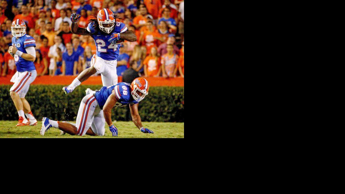 LEAping for more:  Florida running back Matt Jones jumps over teammate Clay Burton during the second quarter of Saturday’s game. Jones scored the game-winning touchdown in the third overtime.