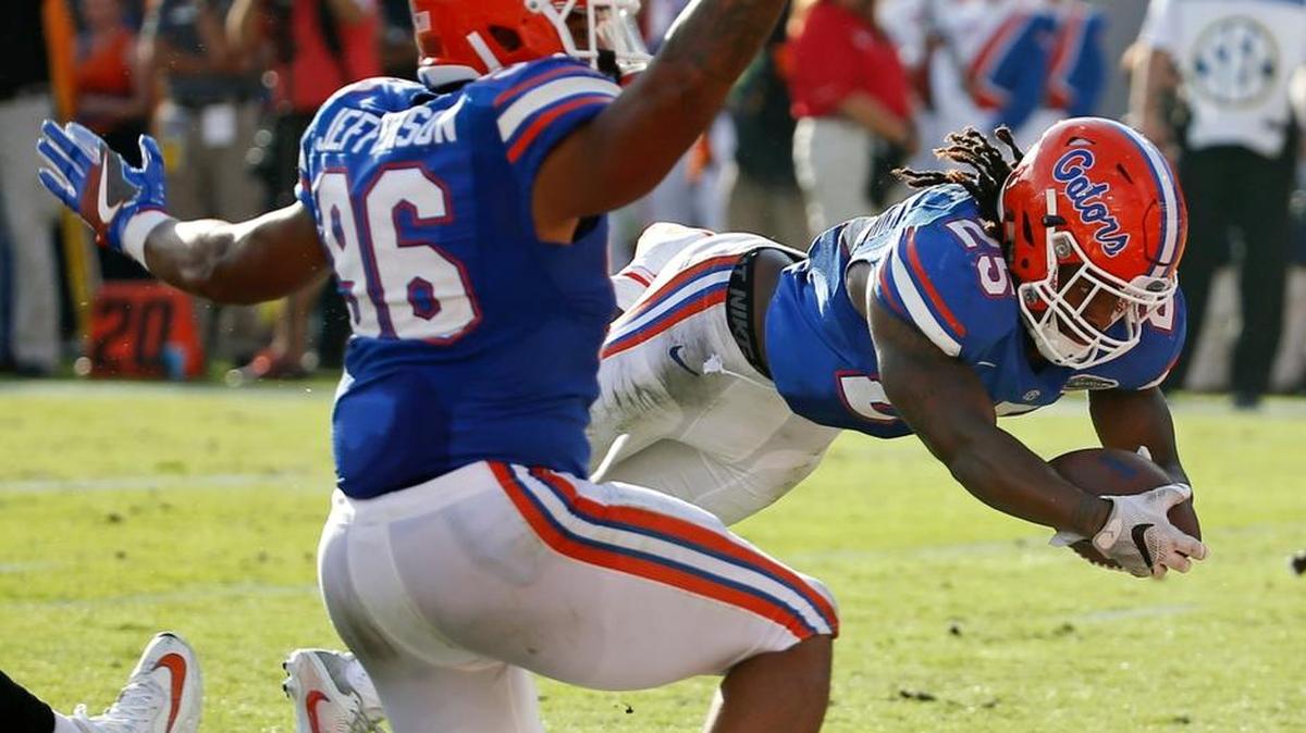 Florida running back Jordan Scarlett (25) dives into the end zone for a 2-yard touchdown past teammate Cece Jefferson (96) during the first half of an NCAA college football game against Georgia, Saturday, Oct. 29, 2016, in Jacksonville, Fla.