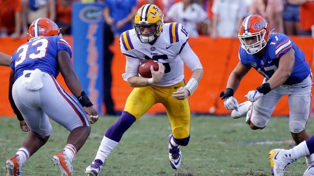 LSU quarterback Danny Etling, center, looks for a way through Florida linebacker David Reese (33) and defensive lineman Jordan Sherit, right, during the second half of an NCAA college football game, Sat., Oct. 7, 2017, in Gainesville, Fla. LSU won 17-16.