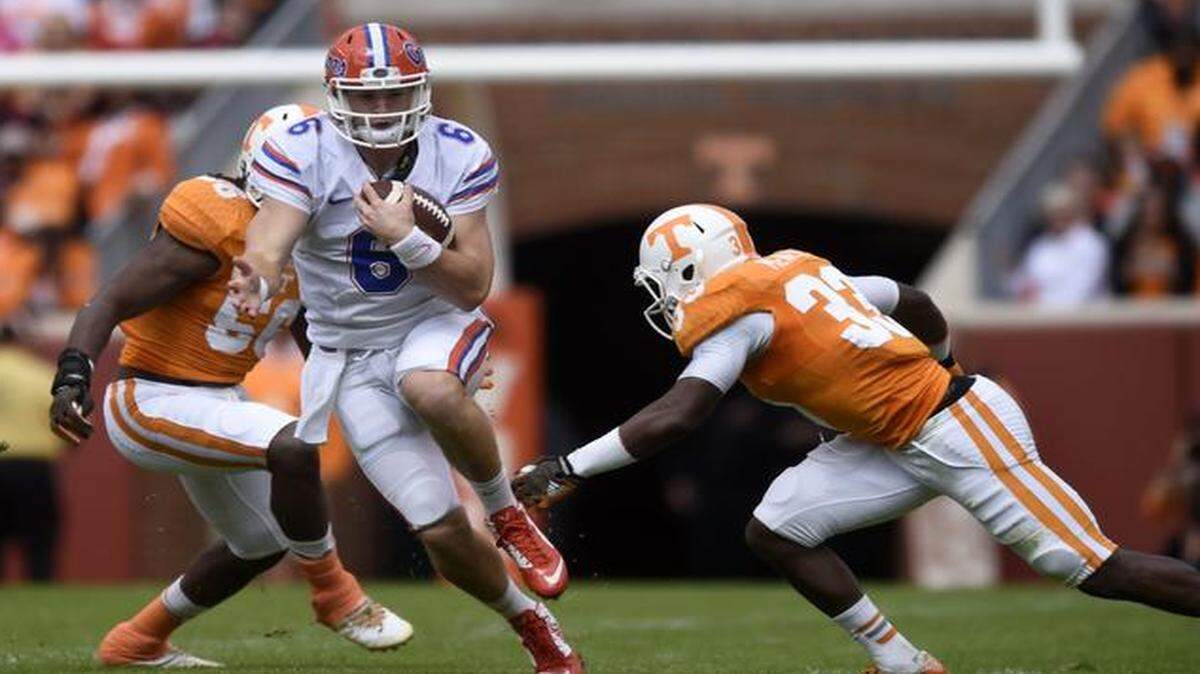 
Florida quarterback Jeff Driskel (6) runs between Tennessee defenders during the first half of an NCAA college football game at Neyland Stadium, Saturday, Oct. 4, 2014, in Knoxville, Tenn.

