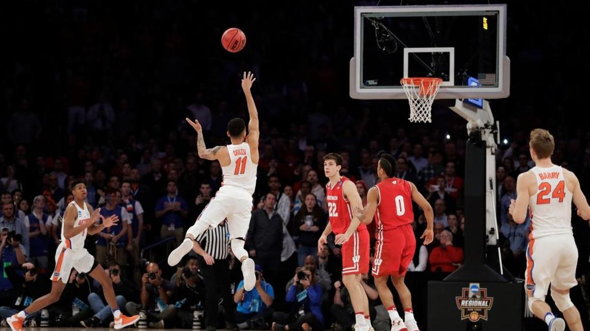Florida guard Chris Chiozza (11) puts up a last second 3-point shot to score the game-winning points against Wisconsin in overtime of an East Regional semifinal game of the NCAA men's college basketball tournament, Sat., March 25, 2017, in New York. Florida won 84-83.