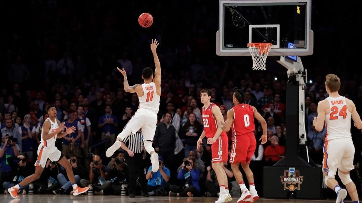 Florida guard Chris Chiozza (11) puts up a last second 3-point shot to score the game-winning points against Wisconsin in overtime of an East Regional semifinal game of the NCAA men's college basketball tournament, Saturday, March 25, 2017, in New York. Florida won 84-83.