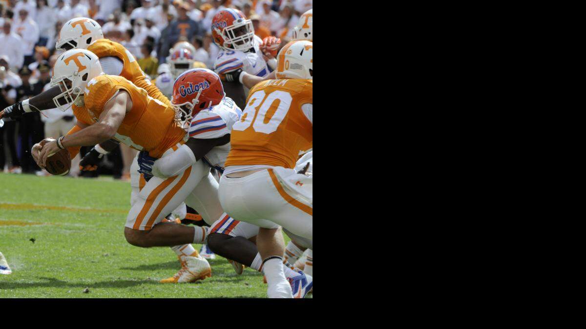 
Tennessee quarterback Justin Worley (14) is tackled by Florida defensive lineman Bryan Cox Jr. at Neyland Stadium, Saturday, Oct. 4, 2014, in Knoxville, Tenn. 
