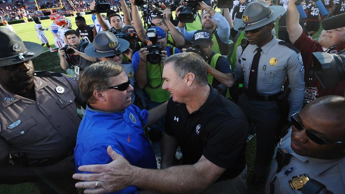 Florida head coach Jim McElwain, left, meets South Carolina interim head coach Shawn Elliott on the field after an NCAA college football game, Saturday, Nov. 14, 2015, in Columbia, S.C. Florida won 24-17.