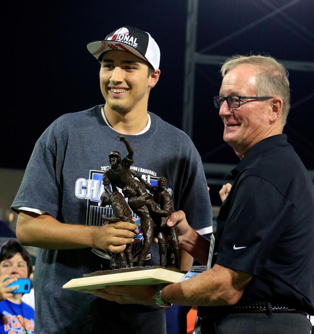 Florida pitcher Alex Faedo, left, receives the Most Outstanding Player trophy from Jack Diesing after Florida defeated LSU to win the NCAA College World Series baseball finals in Omaha, Neb., Tues., June 27, 2017.