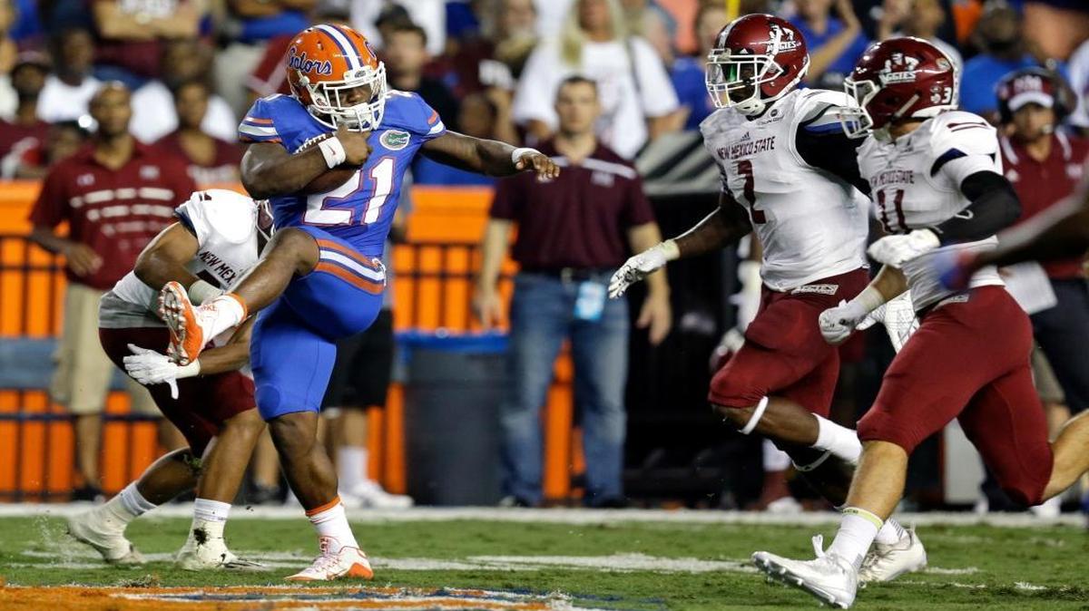 
Florida running back Kelvin Taylor (21) runs past the New Mexico State defense including Terrill Hanks (2) and defensive back Tre Wilcoxen (11) during the first half of an NCAA college football game, Saturday, Sept. 5, 2015, in Gainesville, Fla.
