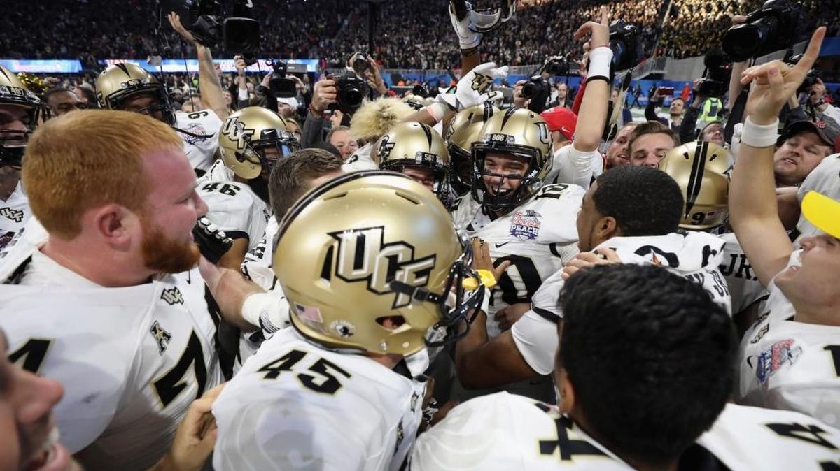 The UCF Knights celebrate defeating the Auburn Tigers 34-27 to win the Chick-fil-A Peach Bowl at Mercedes-Benz Stadium on Jan. 1, 2018, in Atlanta, Georgia.