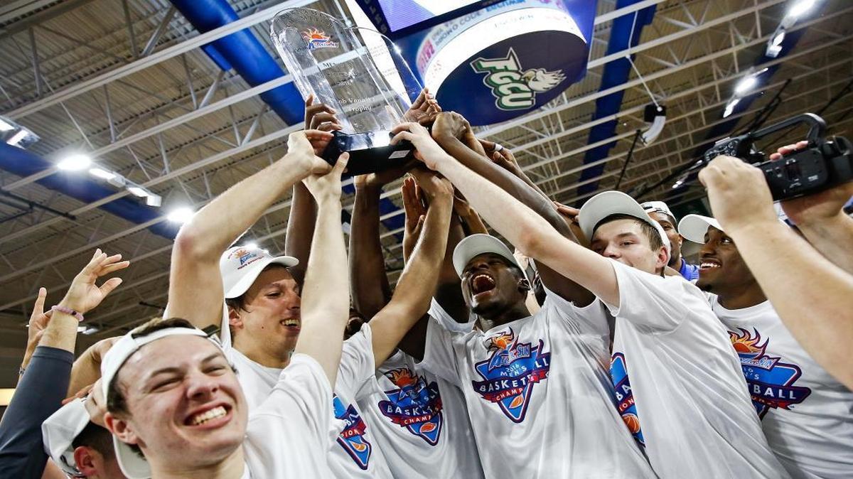 Florida Gulf Coast players celebrate around the Atlantic Sun Championship trophy after defeating Stetson in the NCAA college Atlantic Sun Basketball championship game Sunday, March 6, 2016, in Fort Myers, Fla.
