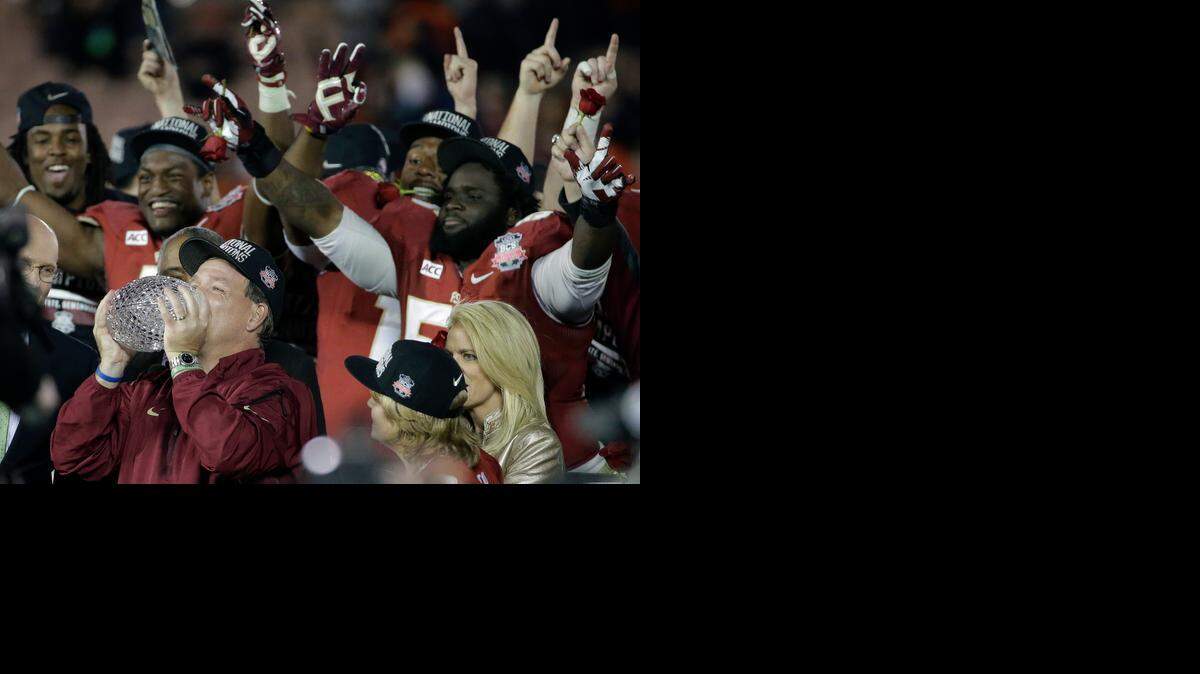 
In the hunt: Florida State head coach Jimbo Fisher kisses what will be the last The Coaches’ Trophy after the BCS National Championship game back in January. College football now has a new format and a new trophy.
