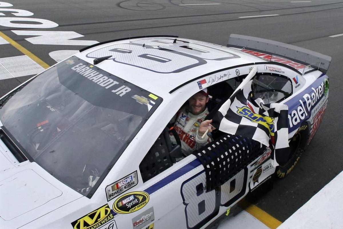 Dale Earnhardt Jr. holds the checkered flag after winning the NASCAR Sprint Cup Series auto race at Pocono Raceway in 2014.