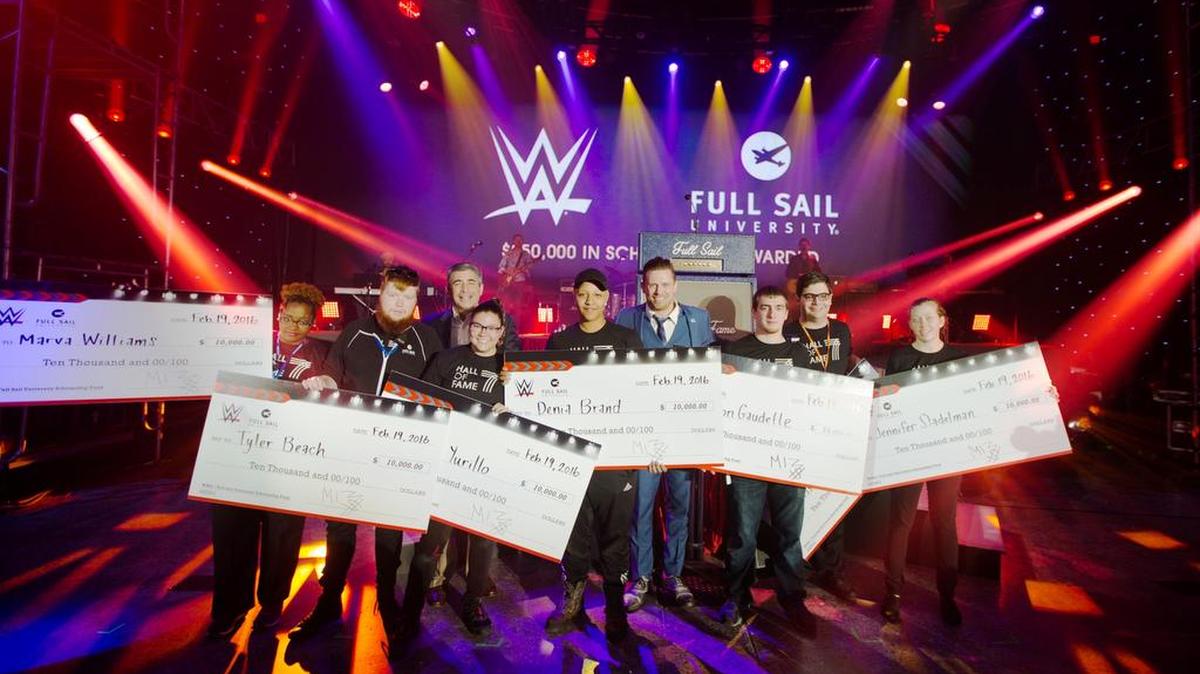 WWE Executive Vice President of Special Events John Saboor (back left) and WWE Superstar The Miz (back right) present seven $10,000 scholarships on behalf of WWE during the Full Sail University Hall of Fame Celebration at Full Sail Live in Winter Park near Orlando. The recipients are from left, Marva Williams, Tyler Beach, Victoria Yurillo, Denia Brand, Clayton Gaudette, Harrison Herbst, and Jennifer Stadelman. WWE has awarded $250,000 in scholarships since forming a partnership with Full Sail University in May 2012.