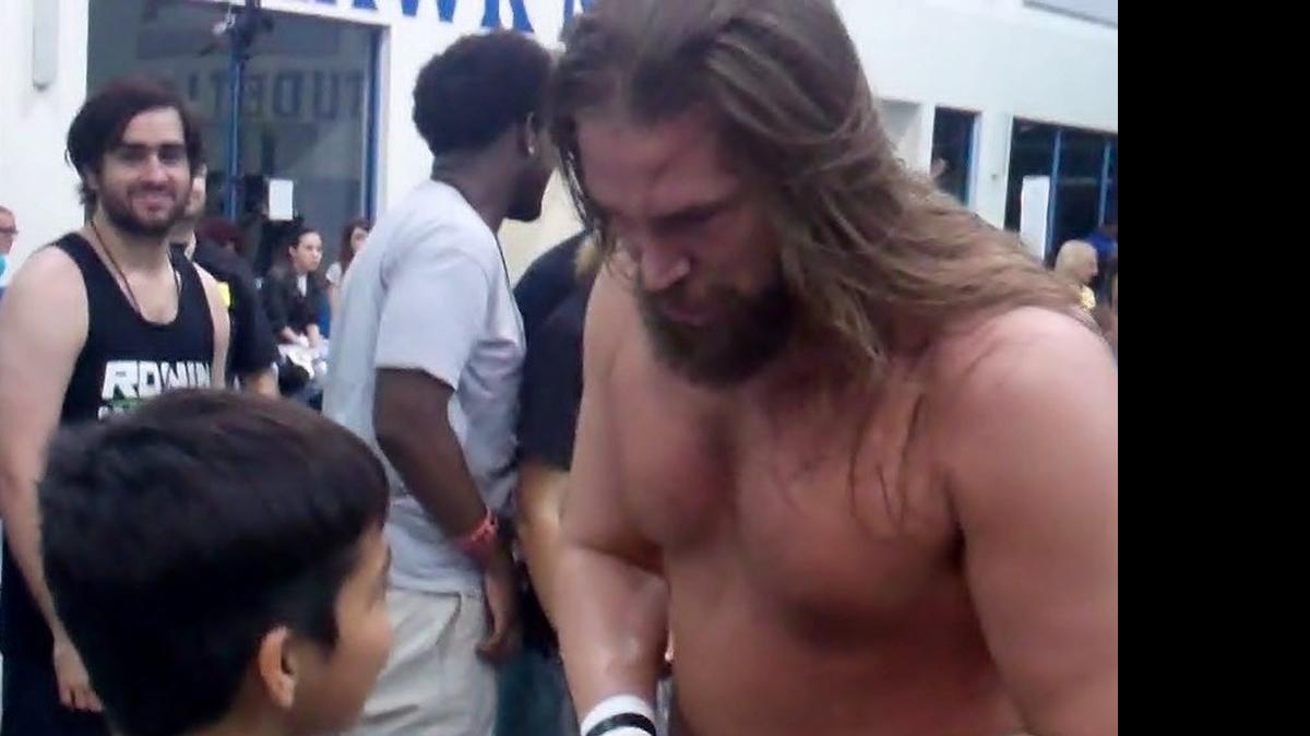 
This young fan, Bryant Suquitana Jr., who cheered Mikaze and heckled Chris Hero, shook hands with Hero after Hero shook hands with Mikaze during Ronin Pro Wrestling 6 at the Broward College South Campus Gymnasium in (South Florida) Pembroke Pines. After beating Mikaze, Hero spoke to Suquitana and then returned to the ring to shake that young fan’s favorite wrestler’s hand. Suquitana reciprocated by extending his hand to Hero after the display of sportsmanship.
