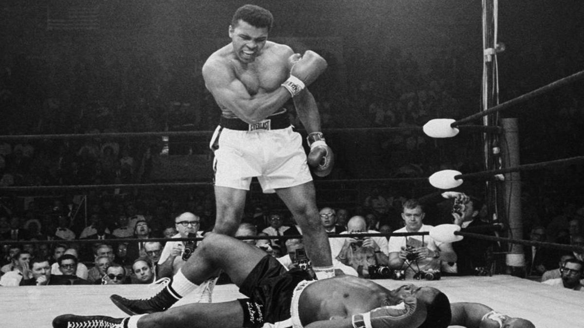 In this May 25, 1965 photo, heavyweight champion Muhammad Ali stands over fallen challenger Sonny Liston, shouting and gesturing shortly after dropping Liston with a short hard right to the jaw in the first round of their title fight in Lewiston, Maine. The bout produced one of the strangest finishes in boxing history as well as one of sports’ most iconic moments.