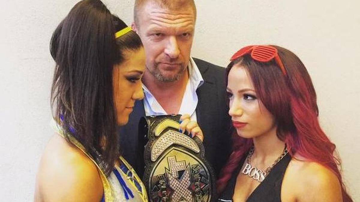 
History in the making as WWE NXT women’s champ Bayley (left) faces former champ The Boss Sasha Banks of WWE’s Team B.A.D. in a 30-minute Iron Woman Match in the main event of NXT TakeOver: Respect on Wednesday, Oct. 7, beginning 8 p.m. EST on WWE Network from Full Sail Live at Full Sail University in Winter Park, near Orlando. Also pictured is Paul Triple H Levesque, WWE’s Executive Vice President (Talent/Live Events/Creative).
