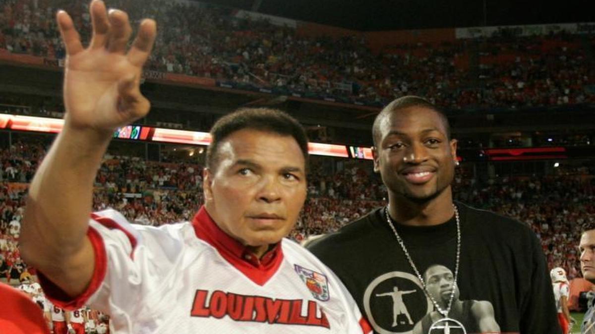 Boxing great Mohammad Ali greets Orange Bowl fans as he and Miami Heat's Dwyane Wade head to midfield for the coin toss at the Orange Bowl football game between Wake Forest and Louisville Tuesday, Jan. 2, 2007, in Miami.
