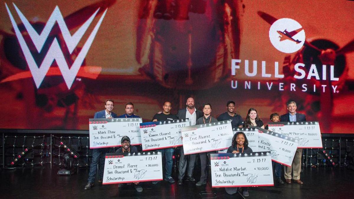 WWE, in partnership with Full Sail University, awarded $10,000 scholarships to 10 Full Sail University students during the Mae Young Classic tapings at Full Sail Live at Full Sail University in Winter Park. Pictured with eight of the scholarship recipients include WWE Executive Vice President, Talent and Live Events Paul Levesque, WWE Executive Vice President of Special Events John Saboor and Full Sail University President Garry Jones.
