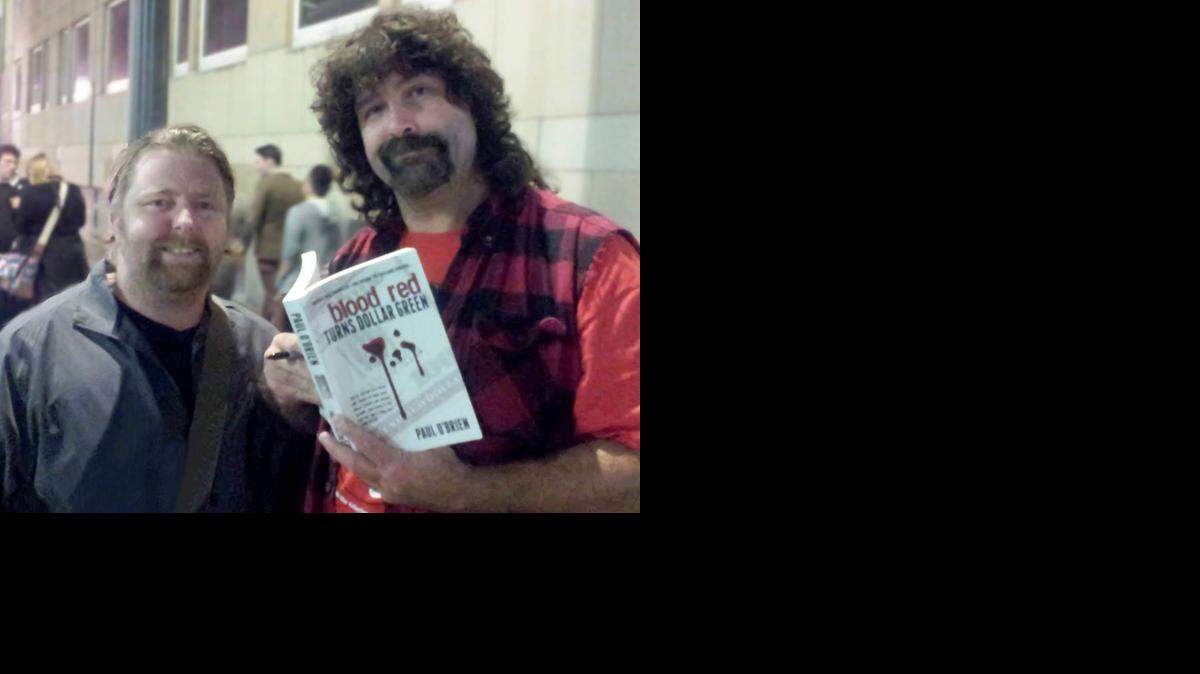 
Author Paul O’Brien (left) of “Blood Red Turns Dollar Green,” getting the stamp of approval from New York Times’ best-selling author and WWE Hall of Famer Mick Foley.
