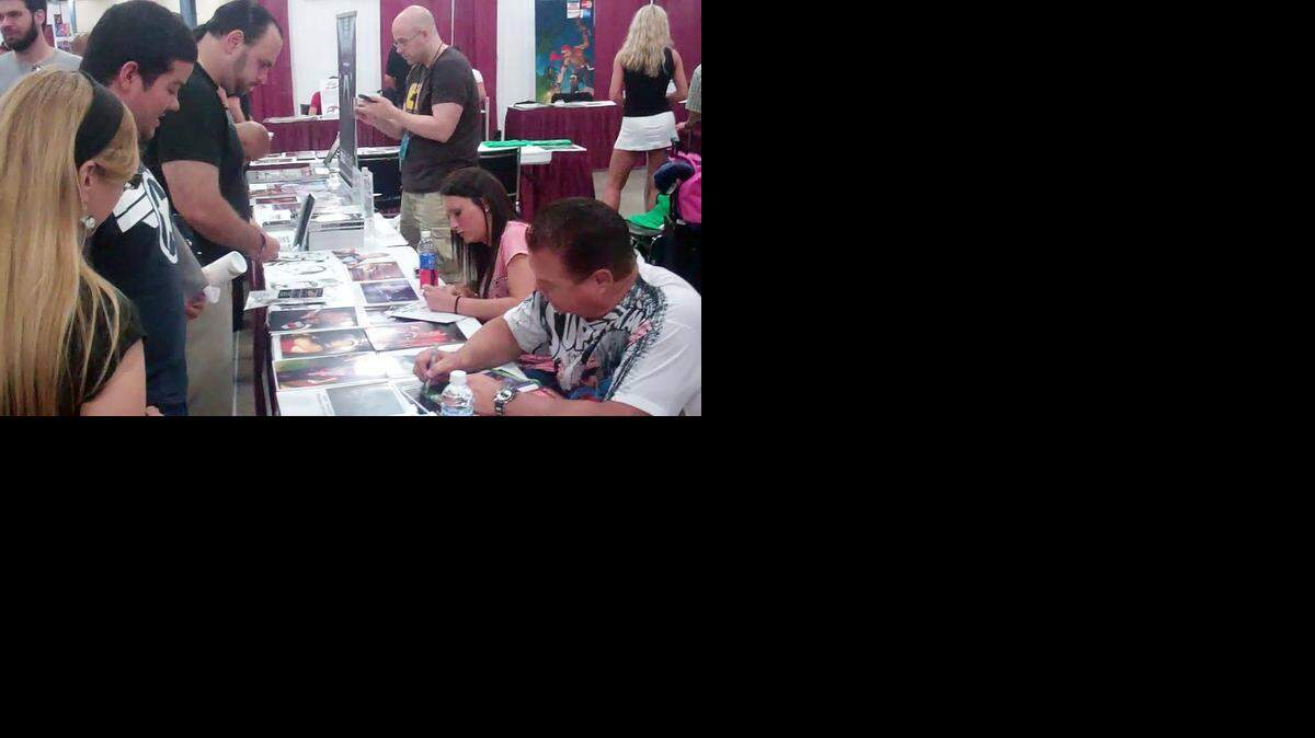 
Writer Michael Kingston (back middle) and WWE Hall of Famer and artist Jerry The King Lawler (front right) meeting fans while promoting Headlocked, a comic book about wrestling, during Florida Supercon in July at the Miami Airport Convention Center.
