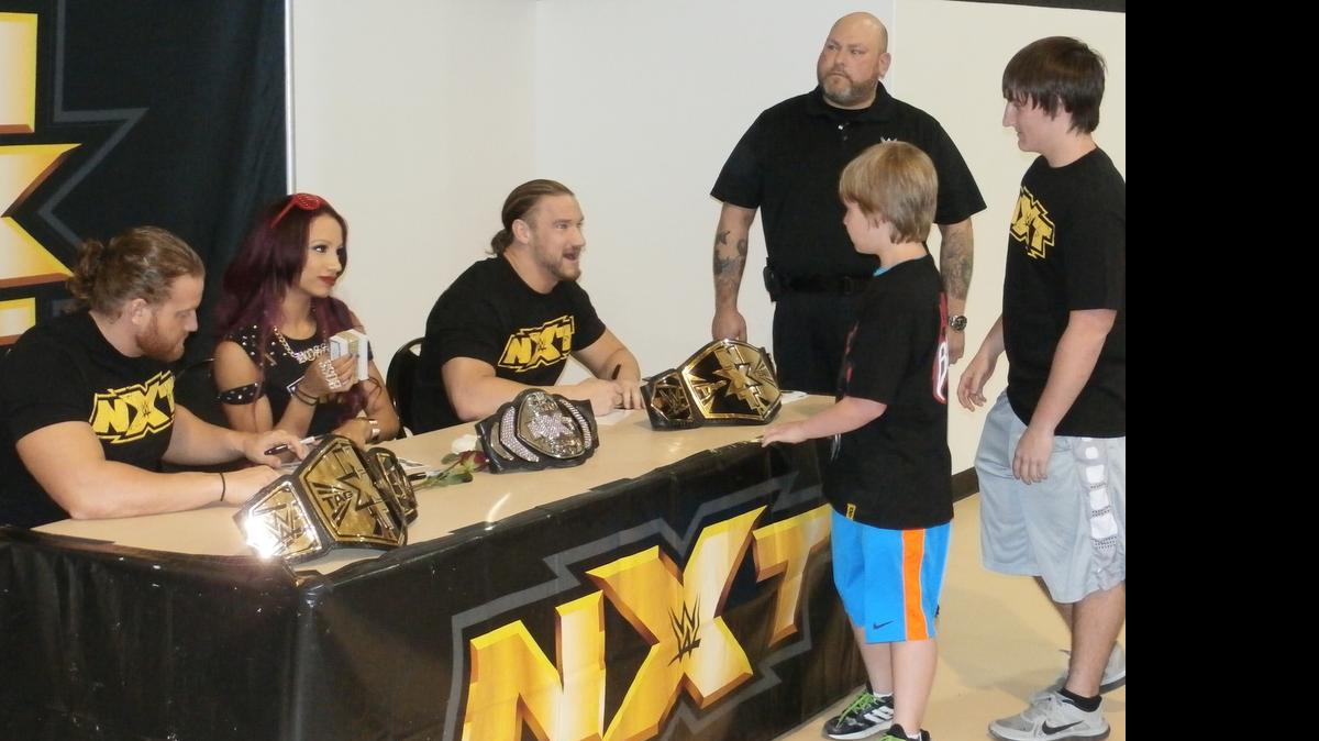 
GOOD AS NXT GOLD: Fans meet NXT tag champs Blake (seated right) and Murphy (seated left) and NXT women’s champ Sasha Banks before a WWE NXT show at the Havert L. Fenn Center in Fort Pierce. NXT is heading south of Fort Pierce in July. Tickets are on sale for NXT shows in Miami and West Palm Beach.
