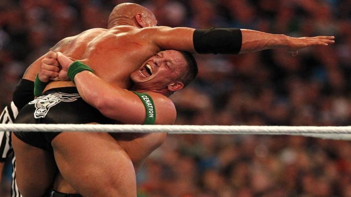John Cena, right, fights Dwayne “The Rock” Johnson during WrestleMania 28 at Sun Life Stadium on April 1, 2012.