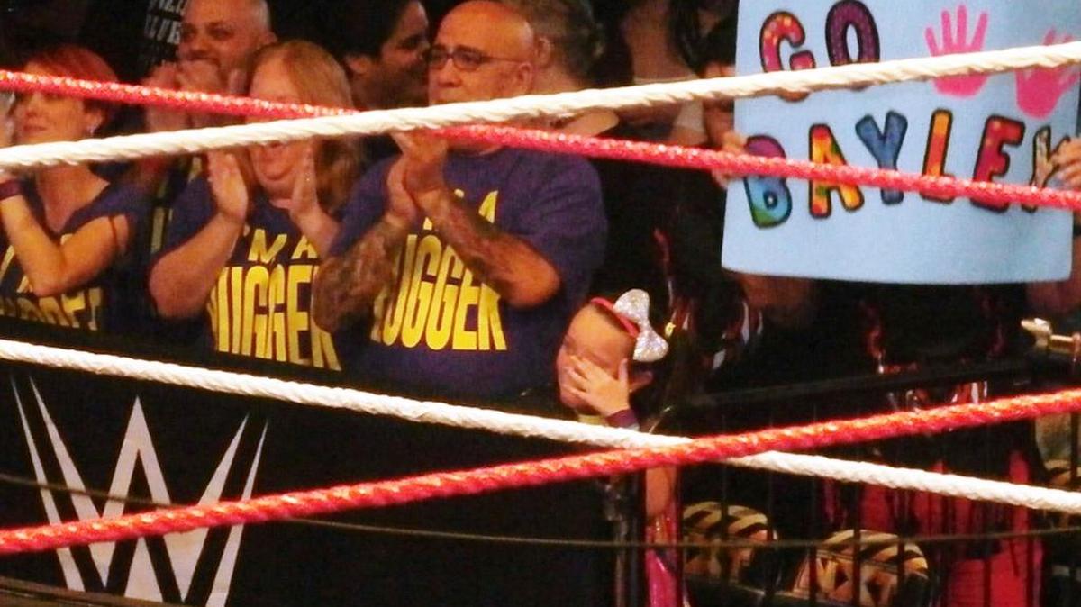 
An emotional Izzy (wearing the now famous headband with silver bow) after her hero NXT women’s champ Bayley won an exciting 30-minute Iron Man match over The Boss Sasha Banks in the main event of NXT TakeOver: Respect on Wednesday, Oct. 7. Banks made Izzy part of the historic match. The show was broadcast live on WWE Network from Full Sail Live at Full Sail University in Winter Park, near Orlando. Pictured next to Izzy is Bayley’s proud dad.
