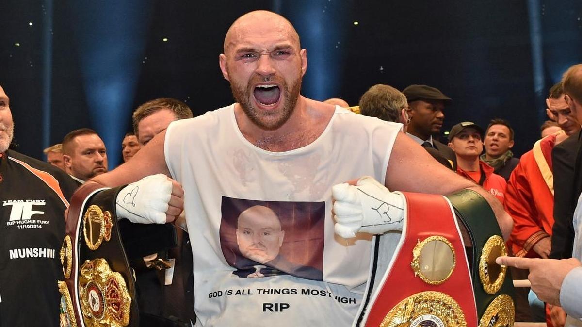 Britain's new world boxing champion Tyson Fury celebrates with the WBA, IBF, WBO and IBO belts after winning the world heavyweight title fight against Ukraine's Wladimir Klitschko in the Esprit Arena in Duesseldorf, western Germany, Sunday, Nov. 29, 2015.