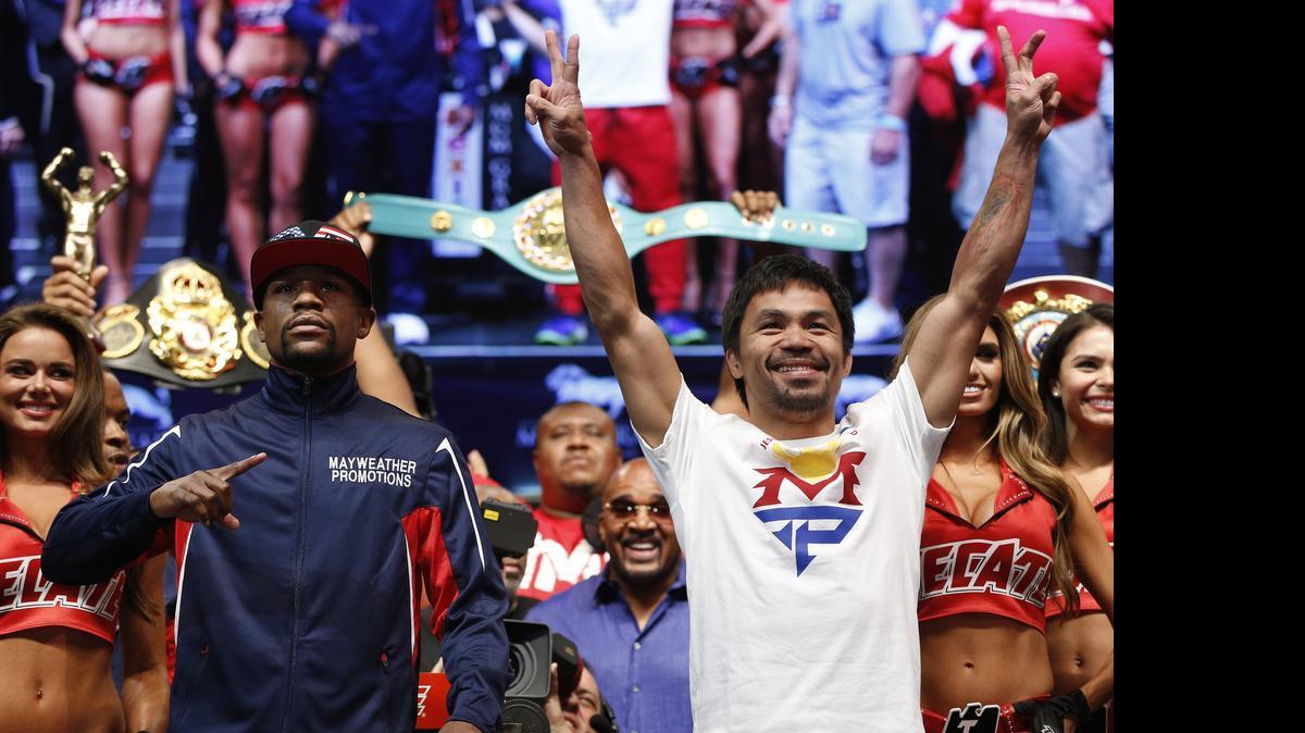 Floyd Mayweather Jr., left, and Manny Pacquiao pose during their weigh-in on Friday, May 1, 2015 in Las Vegas. 

