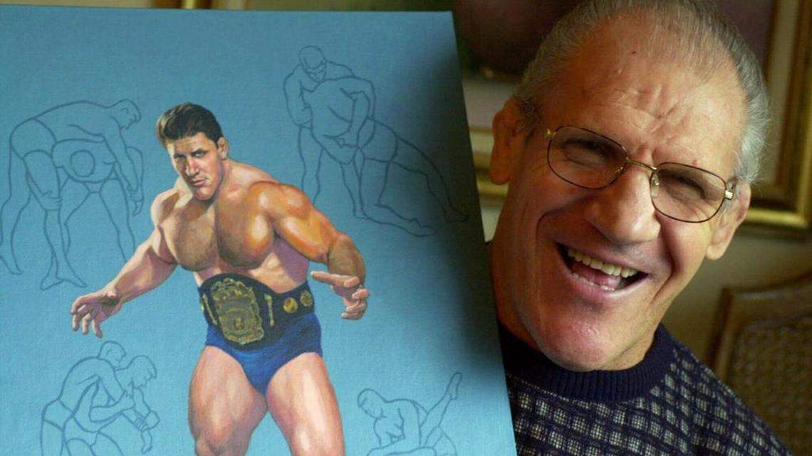 In this Nov. 30, 2000, file photo, former pro wrestler Bruno Sammartino, 65, poses with a painting of him in his pro wrestling prime, weighing 275 pounds in 1965 at age 35, in his Pittsburgh home. Bruno Sammartino, professional wrestling's "Living Legend" and one of its longest-reigning champions, has died. Sammartino was 82. Family friend and former wrestling announcer Christoper Crusie said Sammartino died Wednesday morning, April 18, 2018, and had been hospitalized for two months.
