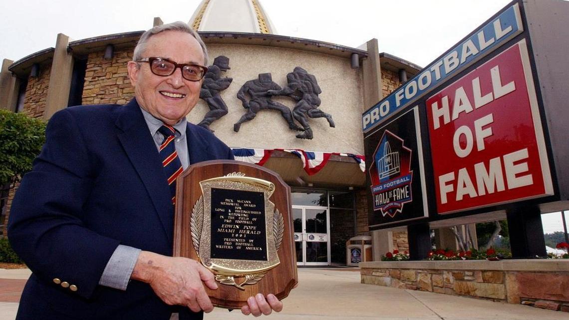 Edwin Pope poses outside the Pro Football Hall of Fame with the plaque he received after winning the Dick McCamm Memorial Award Fri., Aug. 2, 2002, in Canton, Ohio.