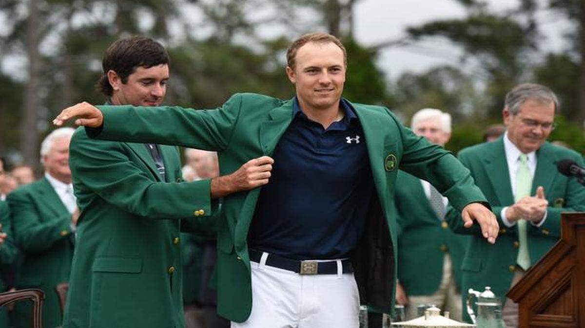 
Defending Masters champion Bubba Watson places the green jacket on 2015 champion Jordan Spieth, who shot a final-round, 2-under-par 70 to win at Augusta National by four shots over Phil Mickelson and Justin Rose for his first major title.

