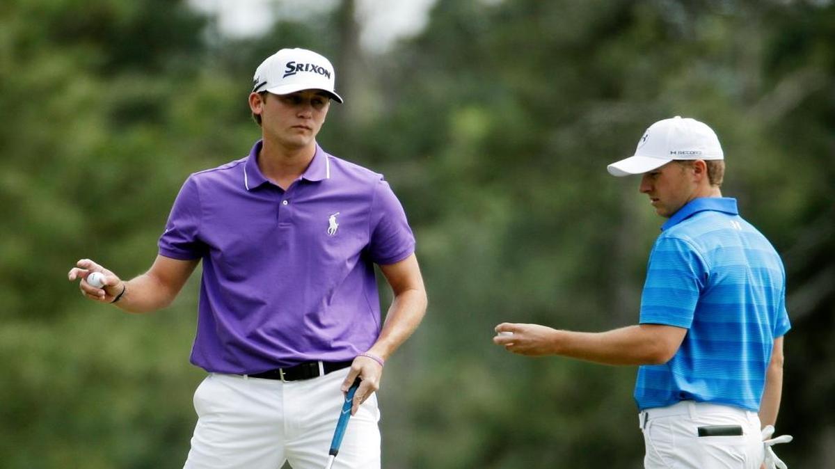 Smylie Kaufman holds up his ball after putting on the third hole while Jordan Spieth prepares to putt during the final round of the Masters golf tournament Sunday, April 10, 2016, in Augusta, Ga.