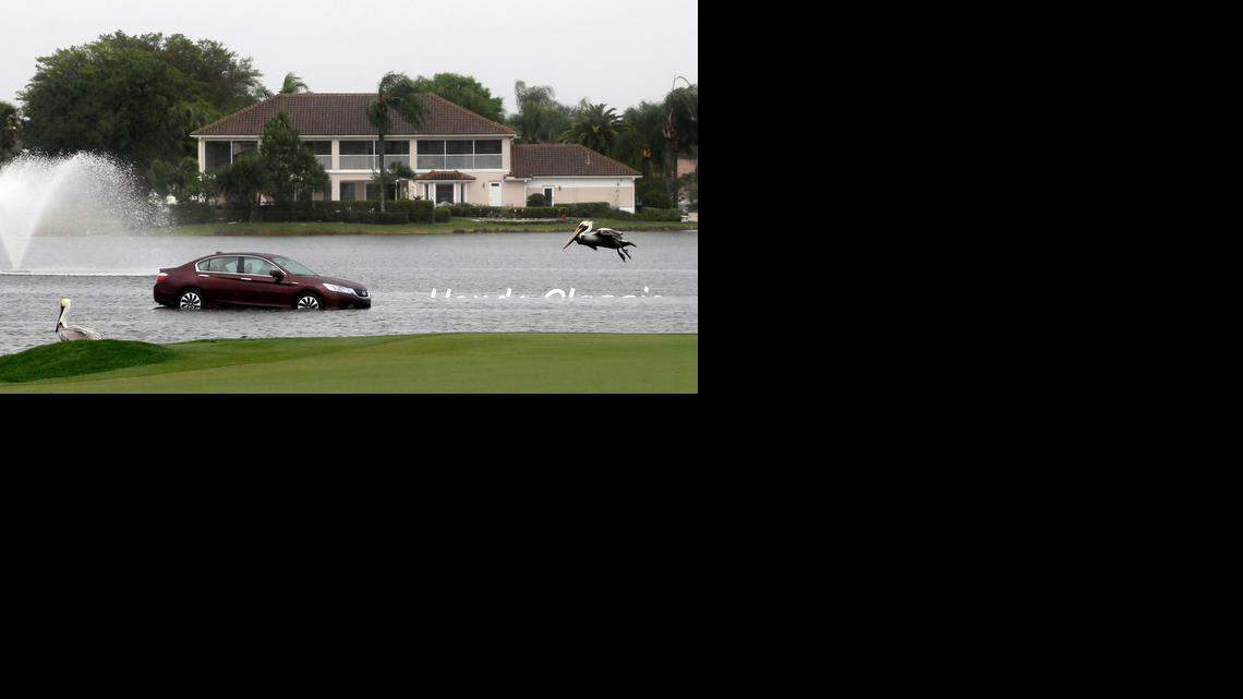 
 A Honda Classic sign to the right of the car in the lake is covered in the water after heavy rain and lightning in Palm Beach Gardens postponed the third round of the tournament until Sunday.
