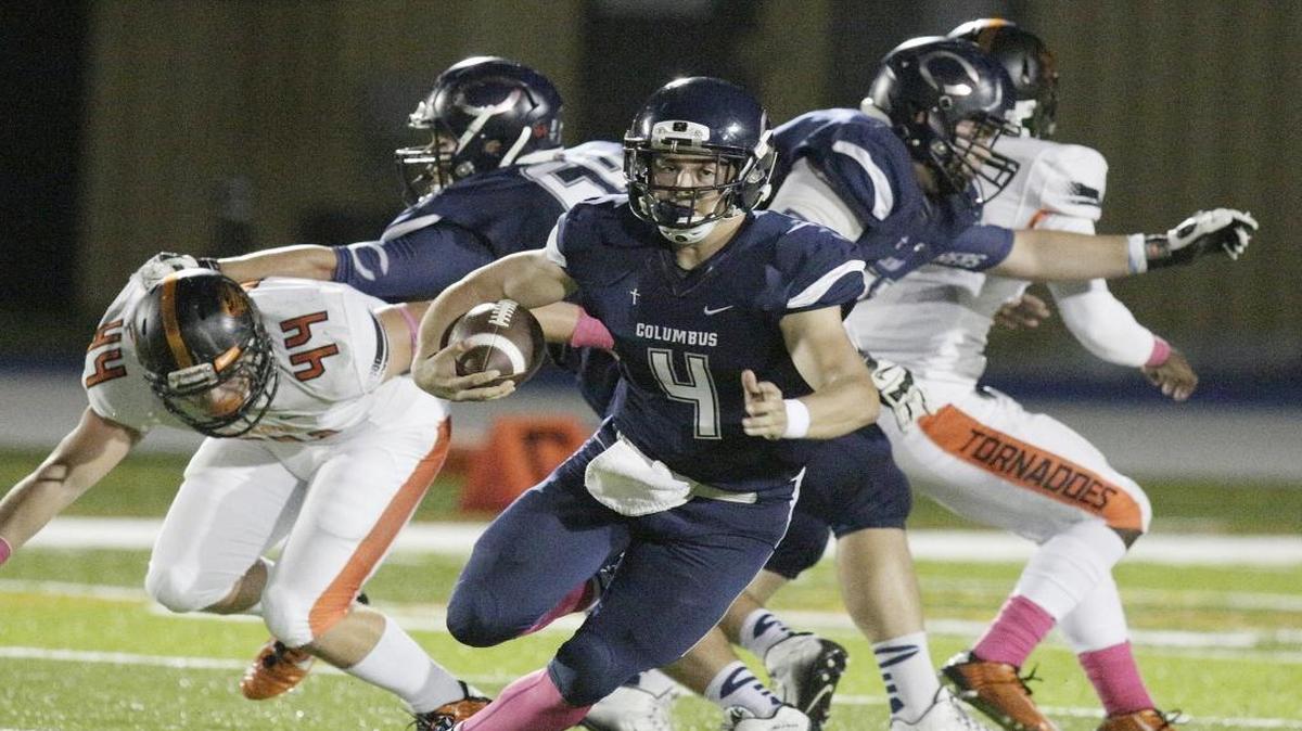 Columbus quarterback Alejandro Ros (4) scrambles for yardage against Booker T. Washington on Friday, Oct. 23, 2015 at Tropical Park Stadium.