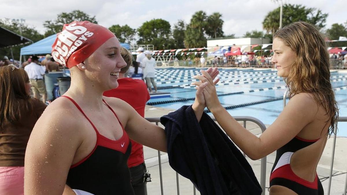 Cooper City High School’s Kathleen Golding gets five from teammate Imriel Coughlin after her victory in the 200 Individual Medley during the BCAA Swimming and Diving Championships on Saturday in Plantation.