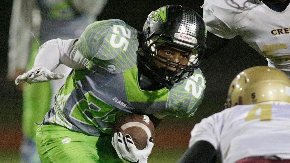 Flanagan’s Darius Alexander (25) tries to escape Coconut Creek defender during their football game on Friday, September 4, 2015 at Flanagan High School in Pembroke Pines.
