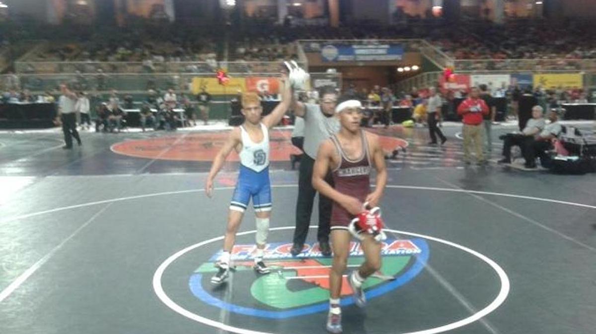 South Dade Elijah Varona has his hand raised in victory by the referee after pinning Strawberry Crest wrestler Manny Rameriz, who brought a 46-4 record into the match.