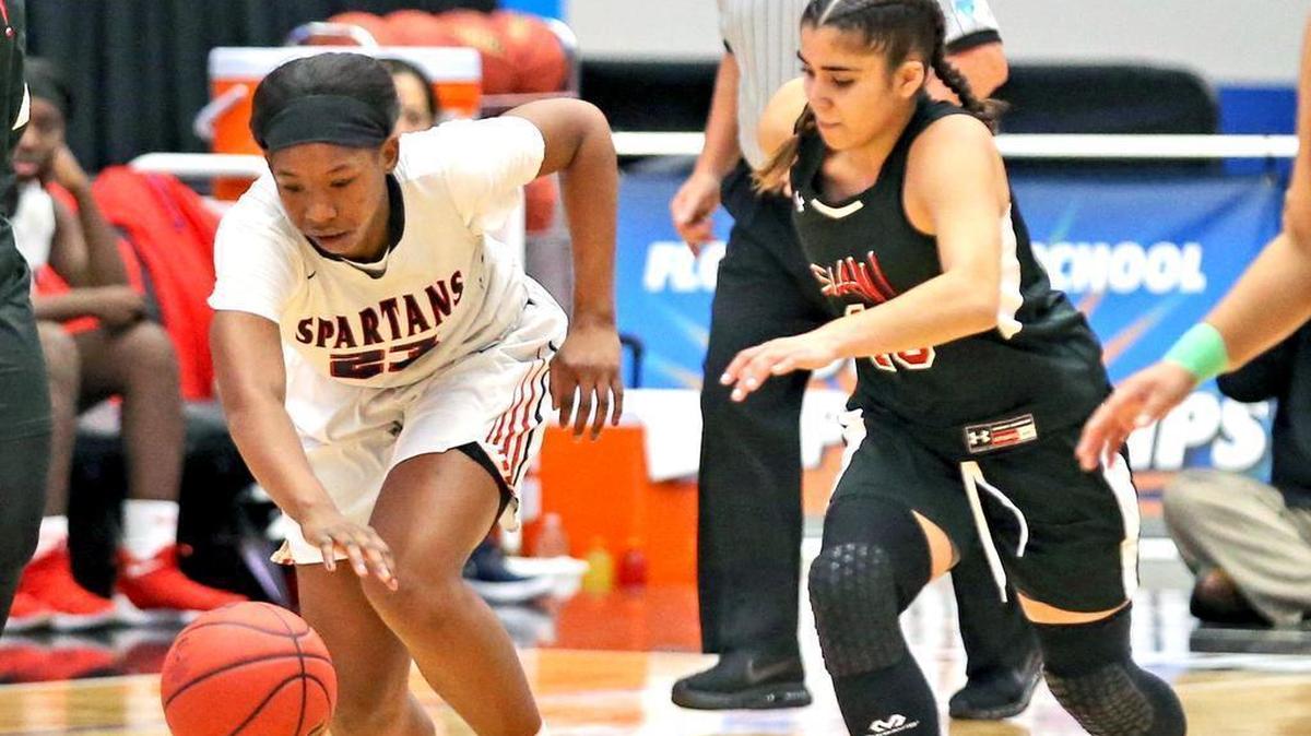 In this Feb. 28, 2018, file photo, Miami Country Day’s Koi Love takes the ball down court as Sports Leadership’s Jacqueline Garcia follows in the 4A semi finals in the Girls 2018 FHSSA Basketball Championships in Lakeland, Florida, Feb. 28, 2018.