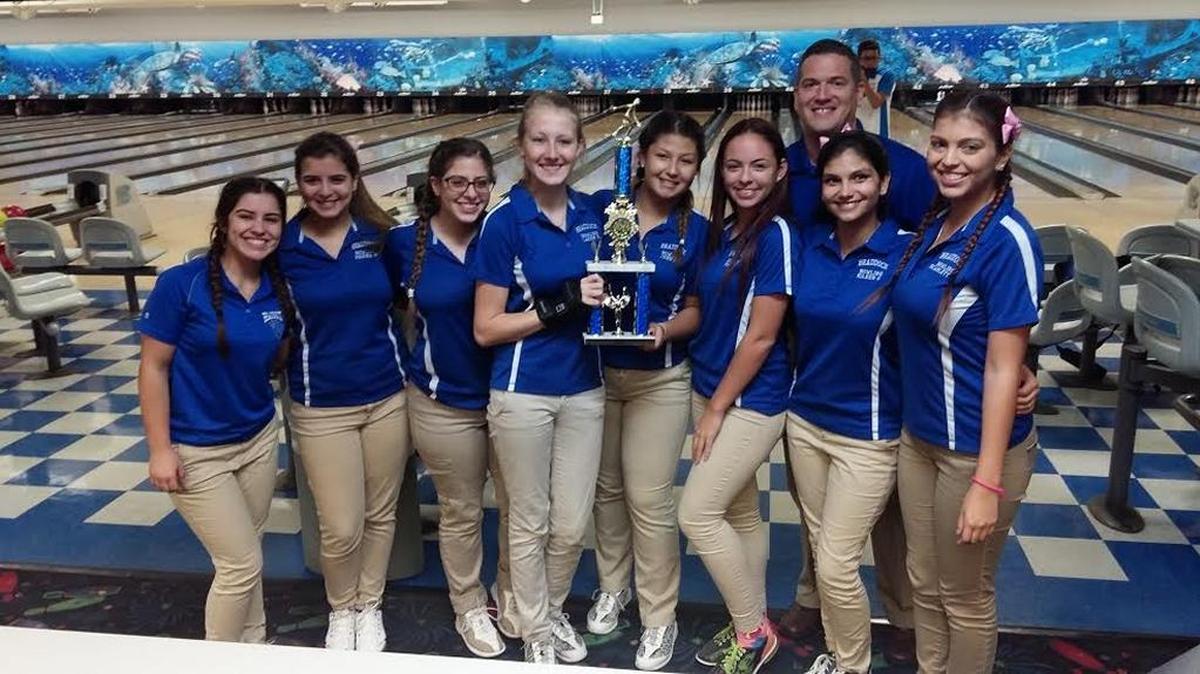 Braddock girls’ bowling team that won the GMAC championship. From left: Patricia Velasco, Regina Monteavaro, Jadon Sallam, Lacey Simpson, Jenny Cortez, Maria Fonseca, Eileen Garcia, Scarlett Garcia. Coach Sebastian Verger in background.