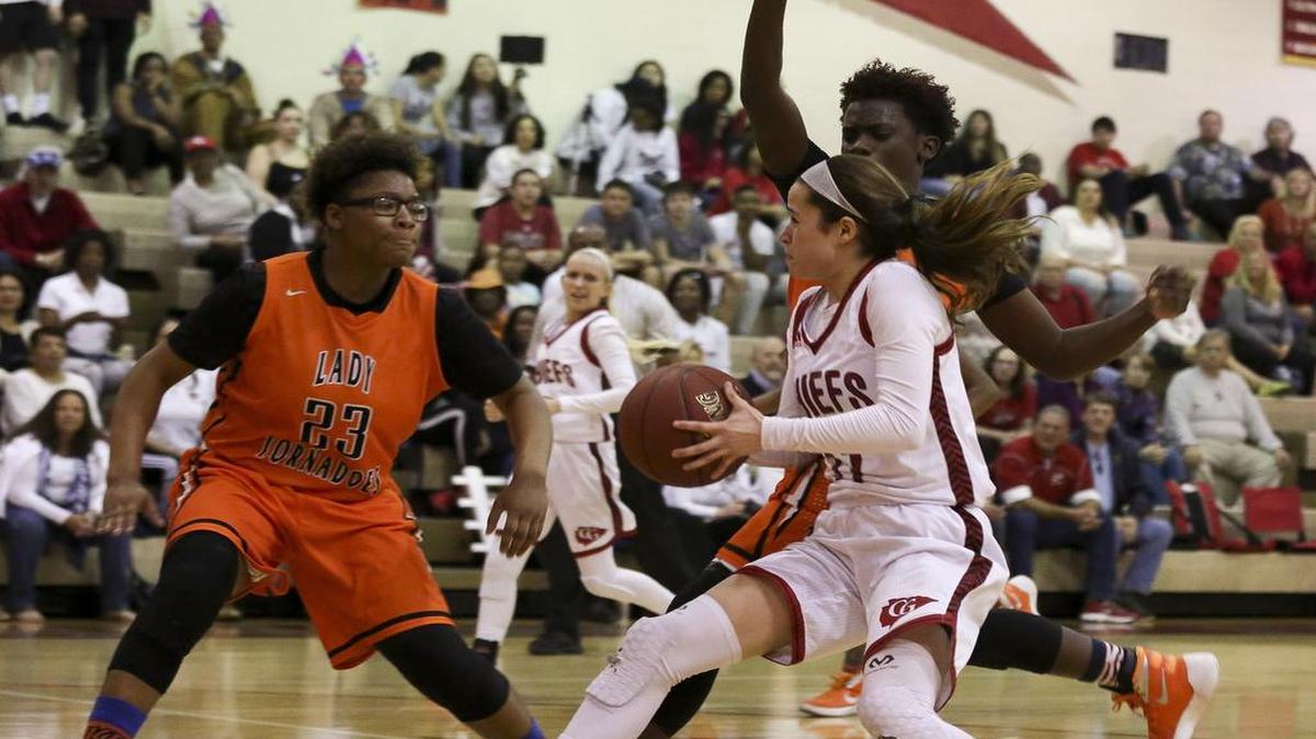 The Chiefs' Christa Tumminello (11) prepares to jump while Booker T. Washington's Crystal Pressley (23) blocks during a Region 4-4A girls' basketball final at Cardinal Gibbons High School in Ft. Lauderdale on Saturday, Feb. 13, 2016. The Chiefs won the game 33-30.