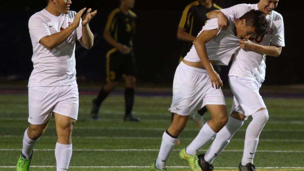 Doral Academy’s Felipe Ospina gets a hug from Juan Castano after Ospina scored against American Heritage in the Region 4-3A boys’ soccer semifinal playoff game at Doral Academy, Feb. 3, 2014.