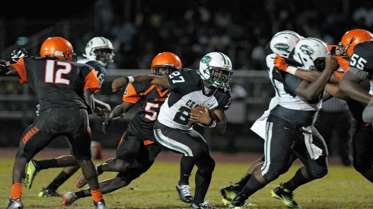 Miami Central running back Kywan Smith is chased by Boyd Anderson linebacker Rickey Lewis during the first half of their Class 6A regional quarterfinal playoff game on Friday night.