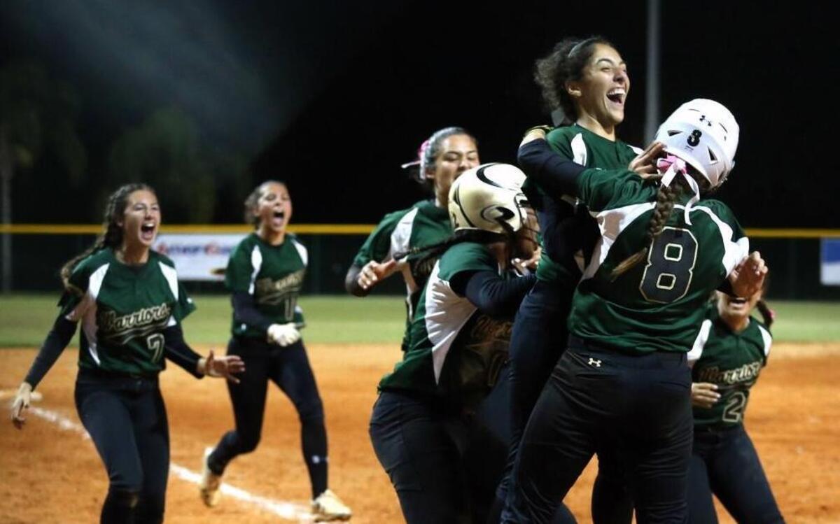 Westminster Christian Dani Amador celebrates and grabs Ally Mena (8) after she scoreed the winning run in the bottom of the seventh inning as they defeat Trinity Christian at the FHSAA Semifinals in Vero Beach, FL, May 17, 2017.