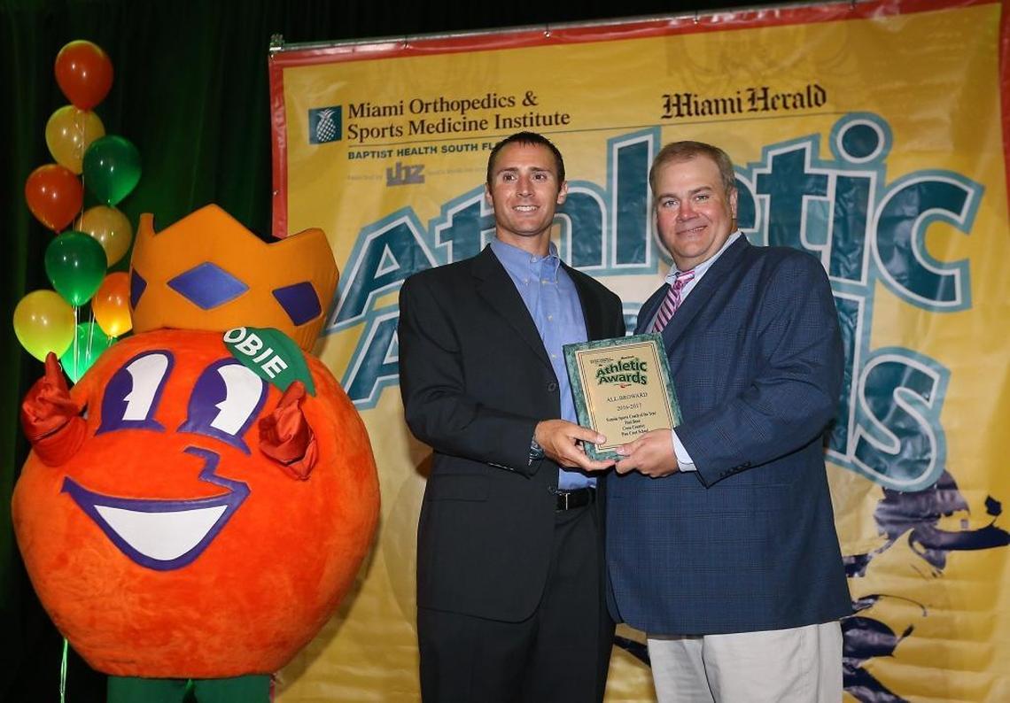 Herald Sportswriter George Richards presents the Female Sports Coach of the Year award to Pine Crest School's Paul Baur at the Miami Herald Broward Athletic Awards banquet at the Signature Grand in Davie on Thurs., May 25, 2017.