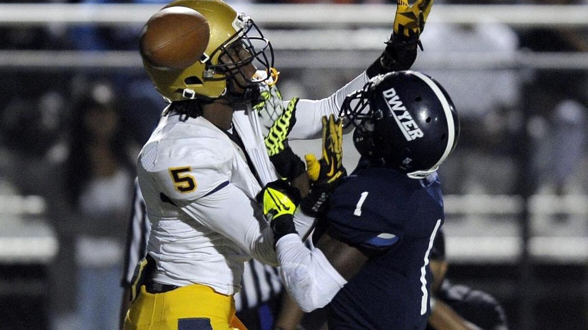 Palm Beach Dwyer’s Johnnie Dixon, right, breaks up a pass intended for St. Thomas Aquinas receiver Devante Peete during their Class 7A regional final Friday, Jan. 29, 2013.