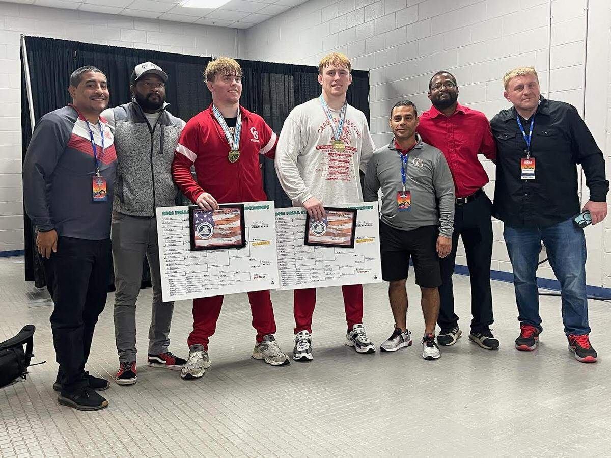 The Mocco brothers (Peter and Michael) with their Cardinal Gibbons coaches and dad after winning state titles to complete undefeated seasons -- combining on a 117-0 mark.