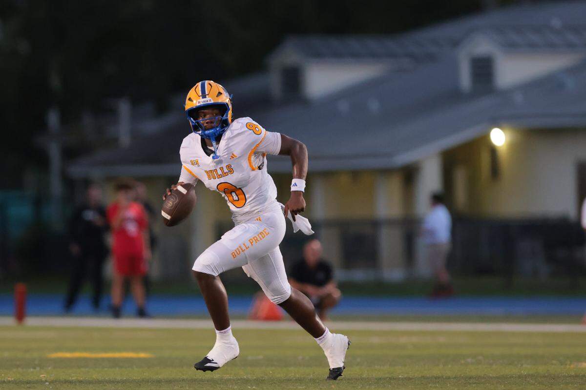 Northwestern Bulls quarterback Neiman Lawrence (8) carries the football against the Columbus Explorers during the first quarter of a high school football game at Tropical Park in Miami, Florida, Friday, September 19, 2025.