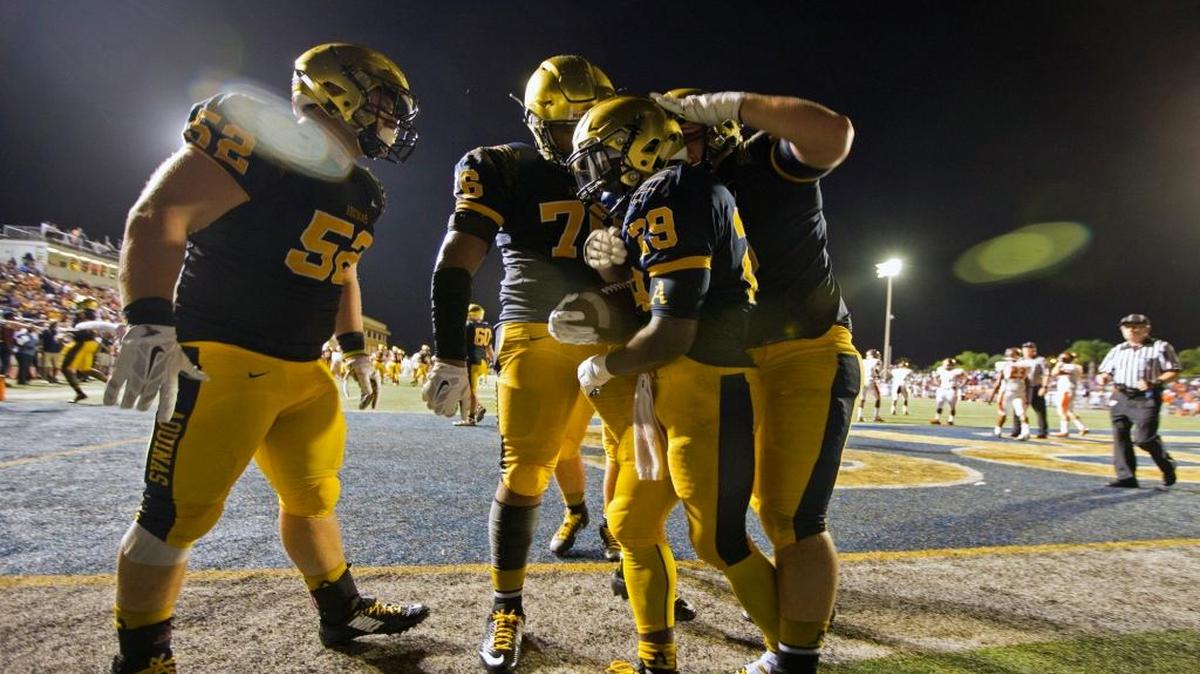 
St. Thomas Aquinas teammates surround Devonta'e Henry-Cole after he scores in the first quarter on Friday, August 28, 2015.
