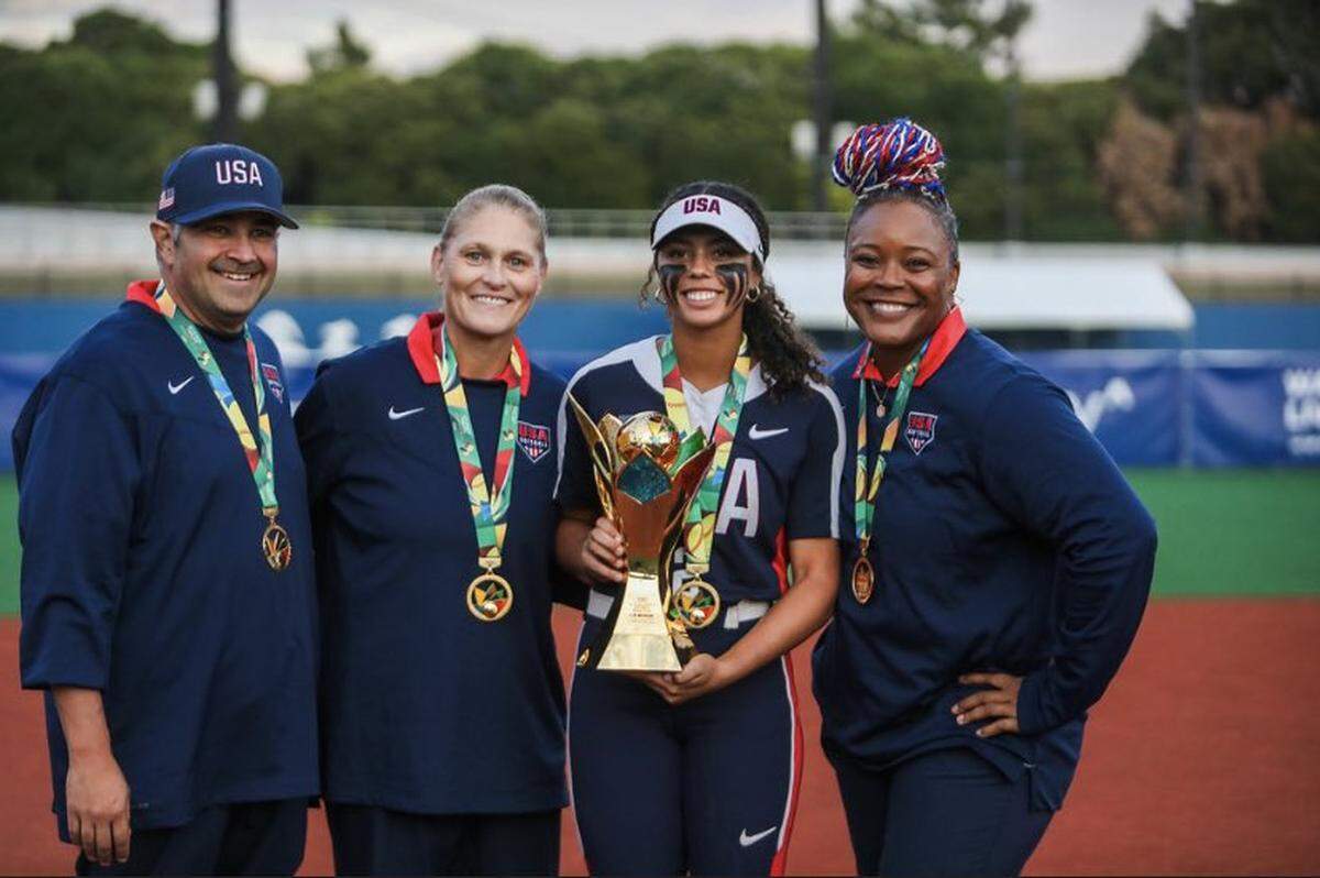 Doral Academy shortstop Anabela Abdullah (with trophy) helped Team USA win the inaugural U-15 Women’s Softball World Cup Championships in Tokyo.