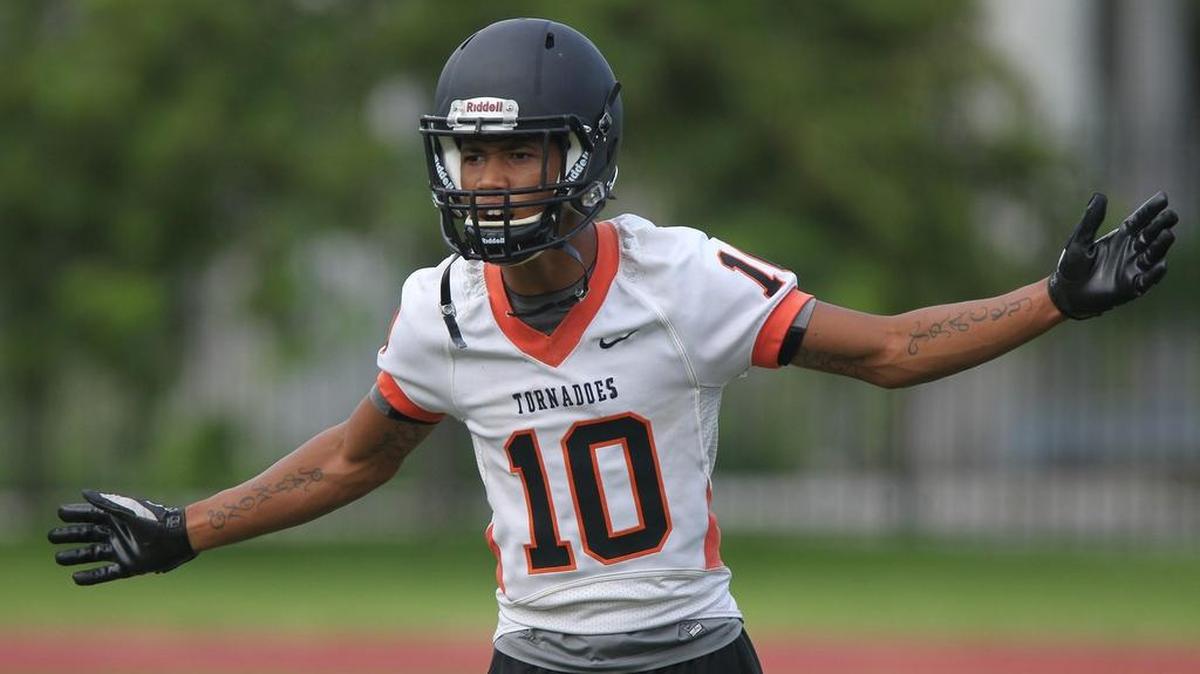 
Booker T. Washington’s Raymond Flanders gestures to teammates during practice Monday, Aug. 3, 2015.
